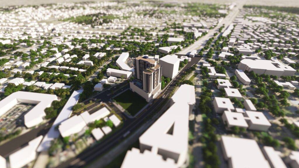 Aerial view of a cityscape with a prominent modern building and surrounding streets.