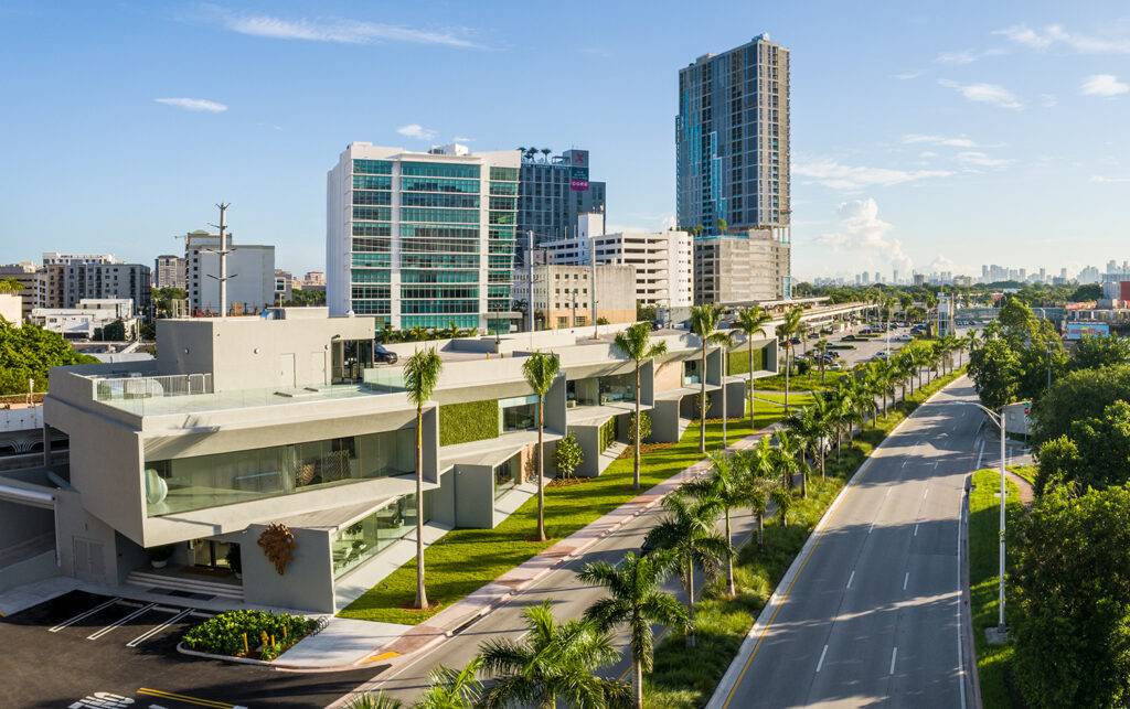 Aerial view of Artefacto Coral Gables showroom with modern architecture and palm-lined street.