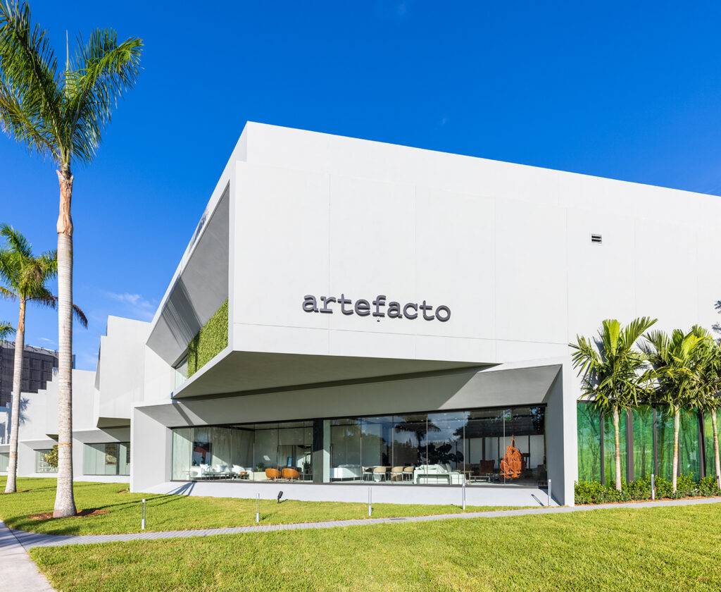 Modern showroom exterior at Artefacto Coral Gables with sleek architecture and palm trees.