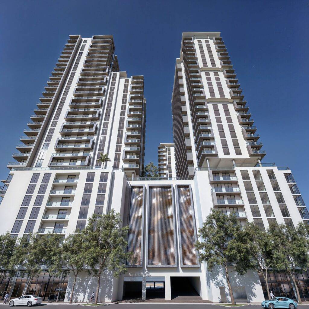 Modern high-rise buildings against a clear blue sky with trees and cars in the foreground.