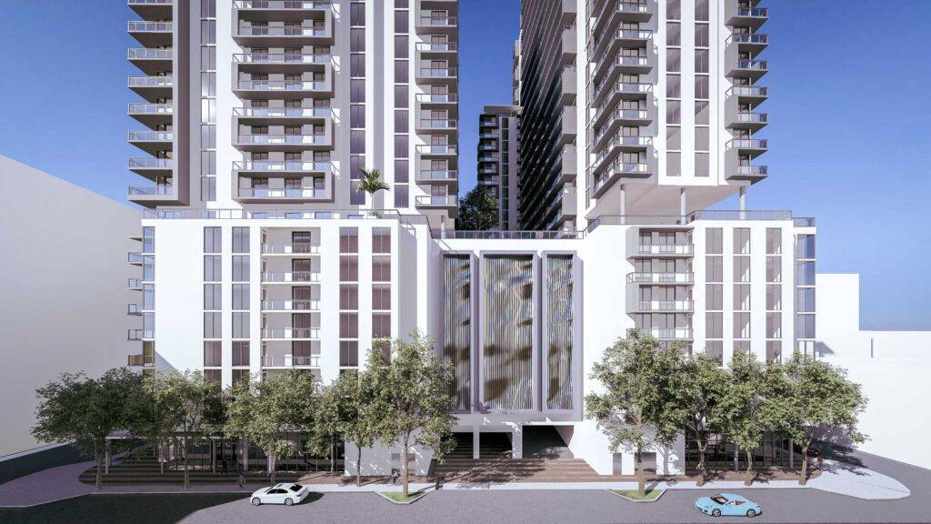 Modern high-rise apartment buildings with tree-lined entrance and parked cars.