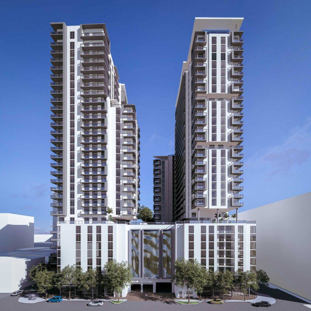 Modern high-rise apartment complex with twin towers against a clear blue sky.