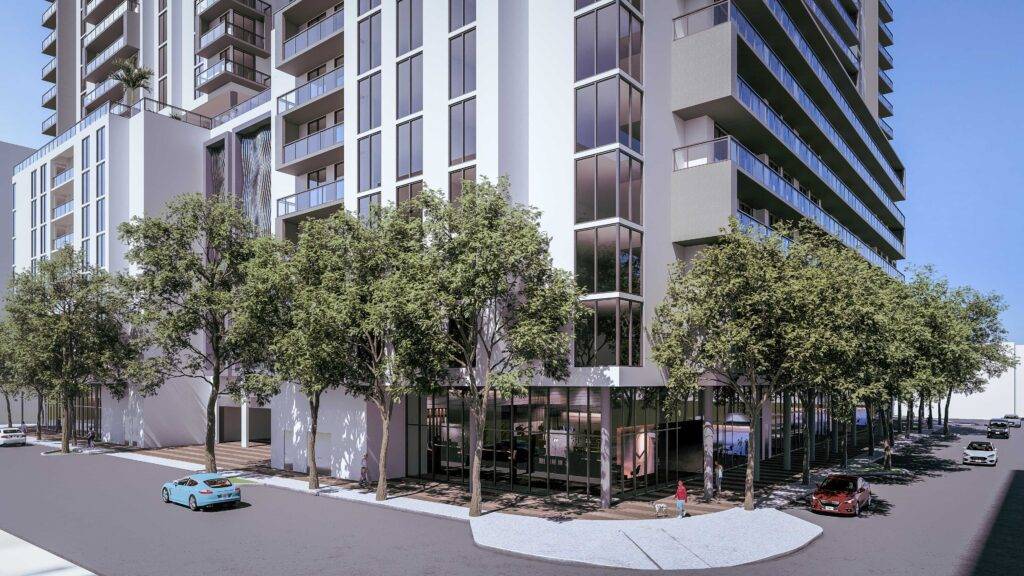 Modern high-rise building with glass balconies and street-level greenery.