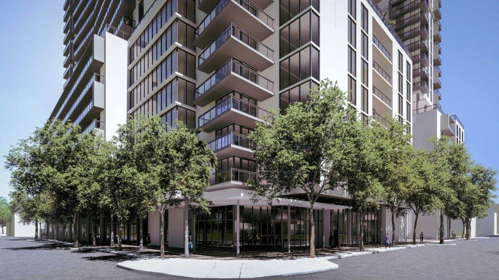 Modern residential building with spacious balconies and lush street-level greenery.