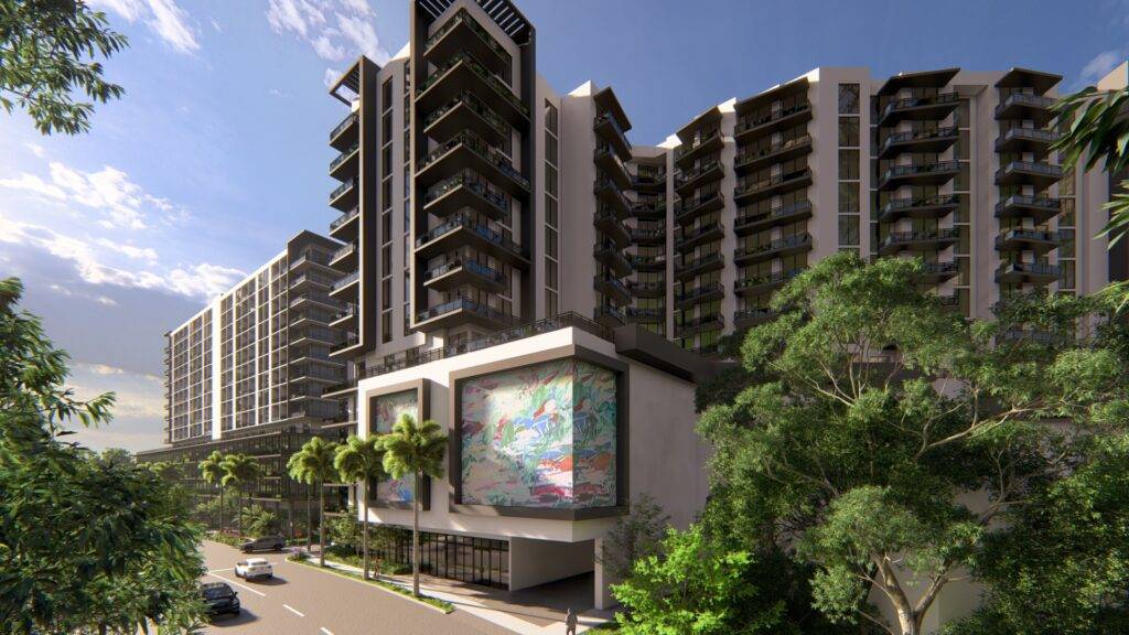 Modern apartment complex surrounded by lush greenery and a clear blue sky.