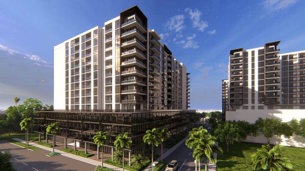 Modern apartment buildings with lush greenery under a clear blue sky.