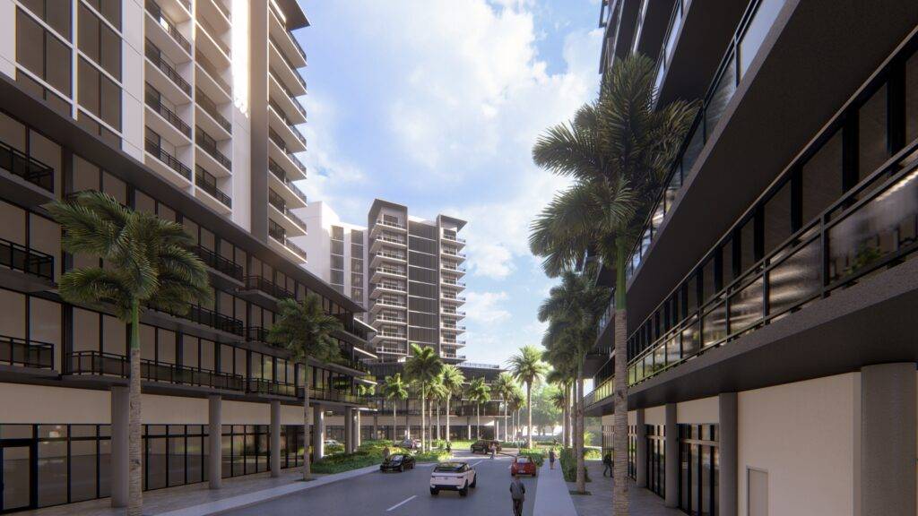Modern urban street with tall buildings and palm trees under a bright sky.