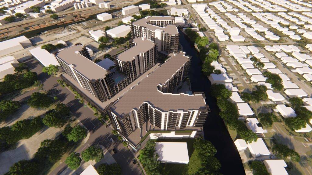 Aerial view of a modern urban apartment complex surrounded by trees and residential neighborhoods.