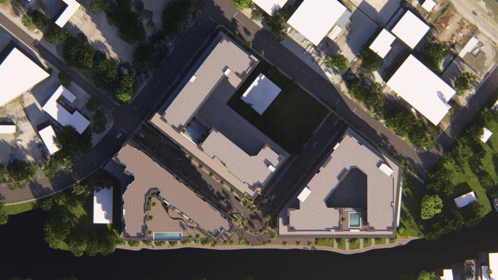 Aerial view of a modern urban complex surrounded by greenery and a waterway.