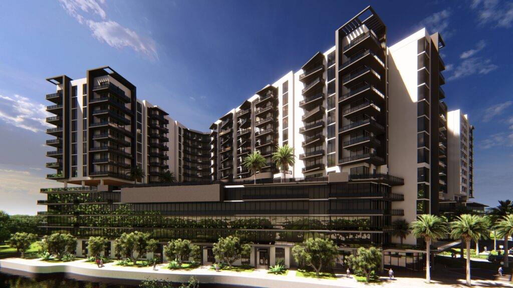 Modern apartment complex with balconies and lush gardens under a clear blue sky.