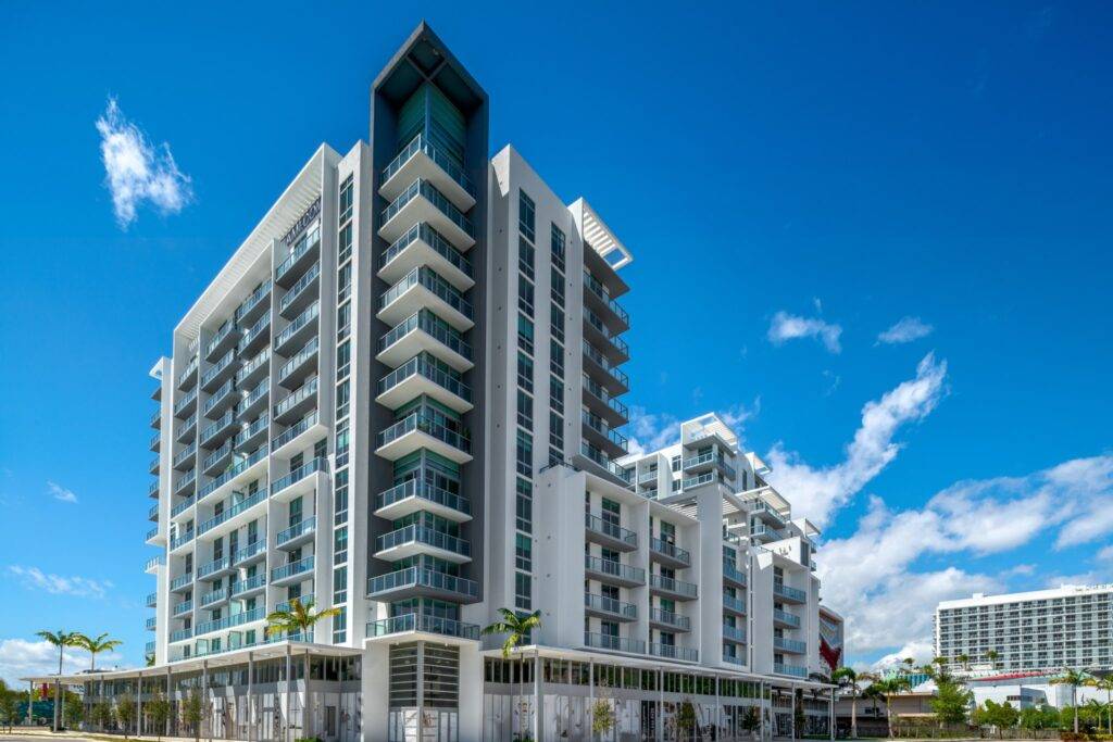 Modern high-rise building with balconies under a clear blue sky.