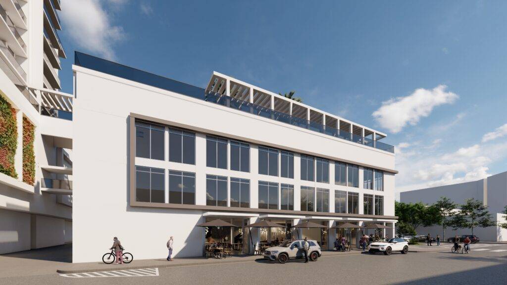 Modern office building with large glass windows and an open terrace under blue skies.