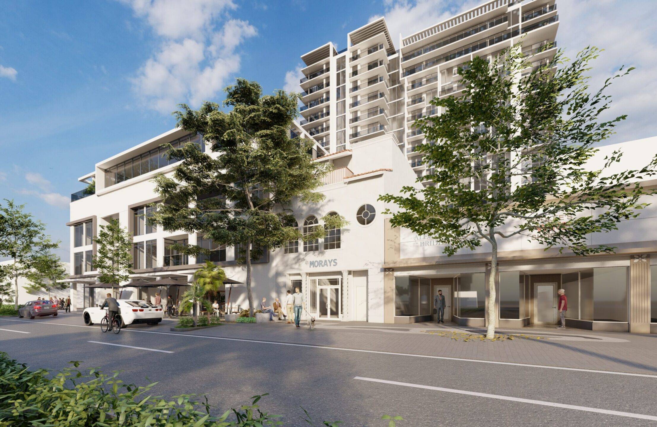 Modern urban architecture with tall glass buildings and lush greenery under a clear blue sky.