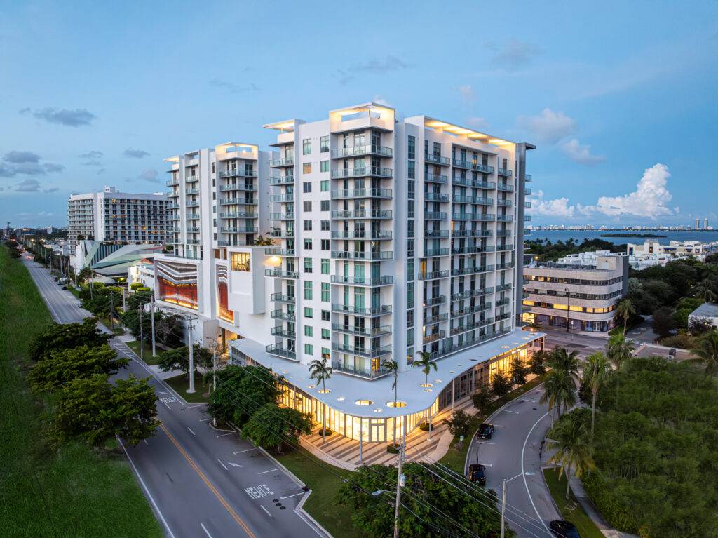 Modern high-rise Quadro Residences with illuminated architecture and surrounding cityscape at dusk.