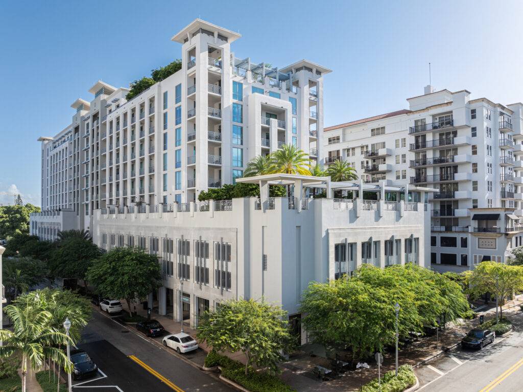 Modern urban apartment building with lush greenery and blue sky