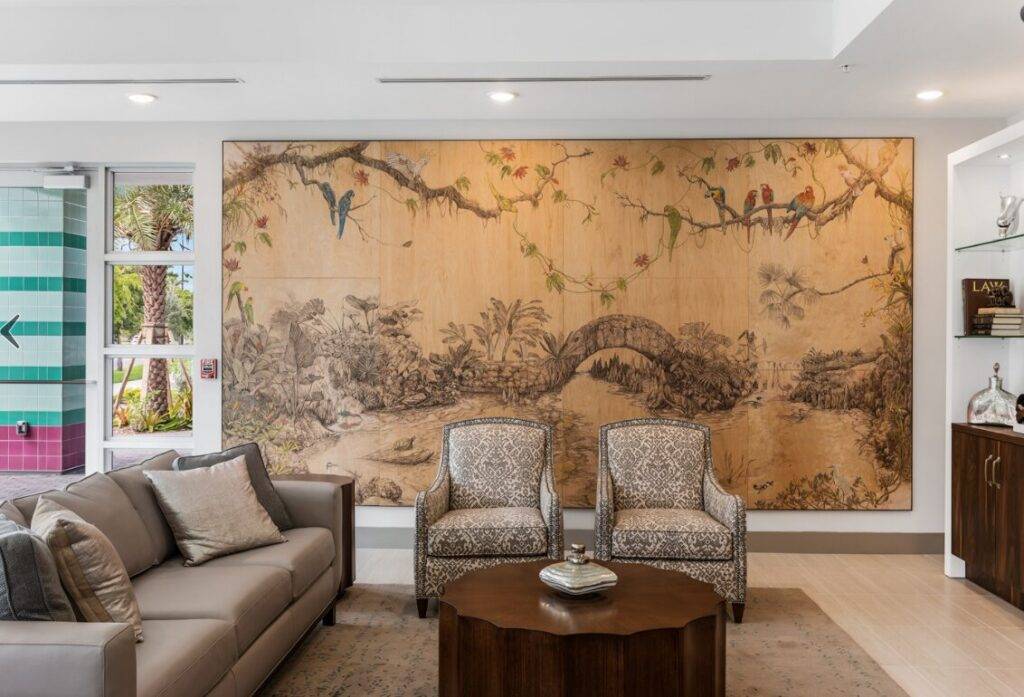 Elegant living room with a large, intricate mural depicting birds and nature above cozy seating.