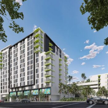 Modern high-rise building with green balconies and surrounding trees under a clear blue sky.