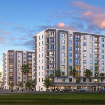 Modern apartment complex with palm trees at sunset