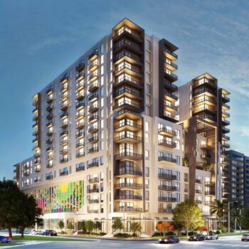 Modern multi-story apartment building with illuminated windows at dusk.