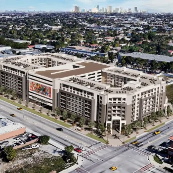 Aerial view of a modern urban development surrounded by roads and buildings in a bustling cityscape.