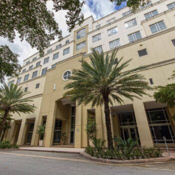 Elegant cream building with palm trees on a sunny day