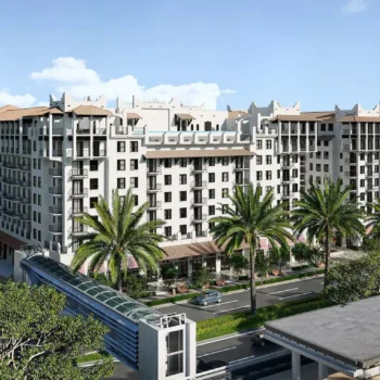 Elegant multi-story building surrounded by palm trees under a bright blue sky.