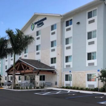 Modern hotel exterior with palm trees and a welcoming entrance.