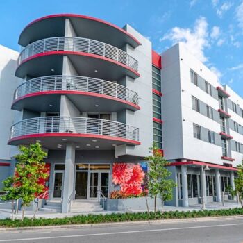 Modern urban apartment building with curved balconies and vibrant street art.