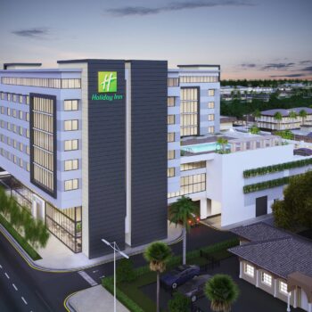 Modern hotel exterior with sleek design and city view at dusk.