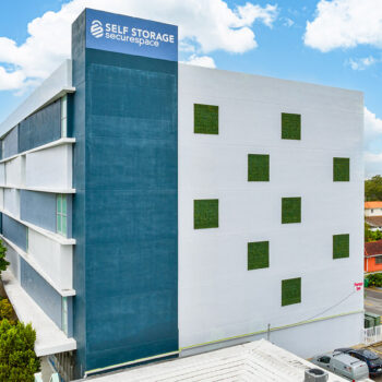 Modern self-storage building with blue and white facade in urban setting.