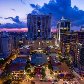 Vibrant city skyline at sunset with tall buildings and colorful lights creating a mesmerizing urban landscape.