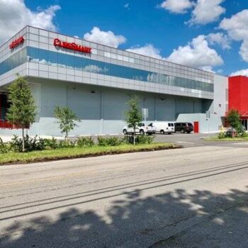 Modern storage facility with sleek architecture under a bright blue sky.